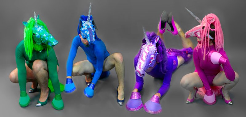 Four people in colorful unicorn costumes with high heels on a gray background.