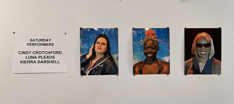 Four portraits of performers, three women and one non-binary person, with a white sign listing "Saturday Performers" to the left.